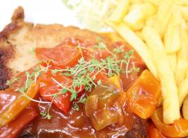 Ein Klassiker ist das saftige Schweineschnitzel mit knusprigen Pommes und pikanter Zigeunersauce 